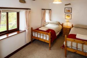 バーナード・キャッスルにあるEast Briscoe Farm Cottagesのベッドルーム1室(ベッド2台、窓付)