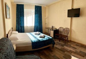 a hotel room with a bed and a table and chairs at Hotel Nord in Voronezh