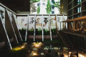 Lumen Hotel & The Lisbon Light Show في لشبونة: فناء به طاولات واضاءة في مبنى