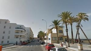 a street with palm trees and buildings on a beach at Cádiz caleta modulo in Cádiz