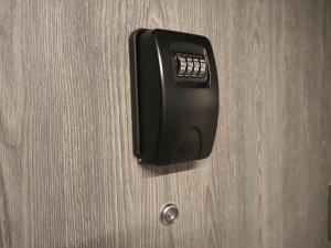 a black phone is hanging on a wooden door at Apartament Kołobrzeska in Piła