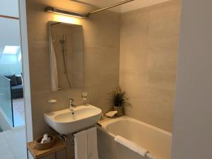 un bagno con lavandino e vasca da bagno di Zürich Niederdorf - Grossmünster a Zurigo Altre 14 foto