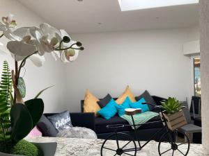 ein Wohnzimmer mit einer blauen Couch mit Kissen in der Unterkunft Gästewohnung Mönchengladbach in Mönchengladbach