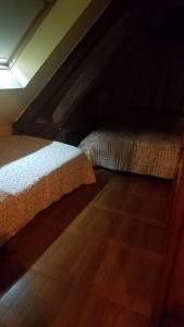 een slaapkamer met 2 bedden en een houten vloer bij Ferme bressane les Arums in Mervans