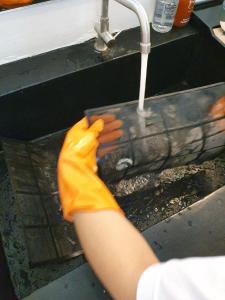 a person in yellow gloves washing a sink at Hotel Chuan Chom The High Resort Saraburi - SHA Plus in Sara Buri