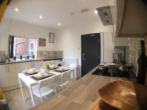uma cozinha com uma mesa e cadeiras numa cozinha em Townhouse @ 87 Walthall Street Crewe em Crewe