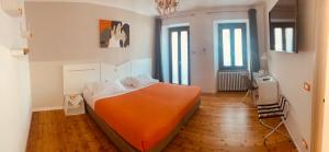 sypialnia z pomarańczowym łóżkiem w pokoju w obiekcie BB BORGO BIELLA w mieście Candelo