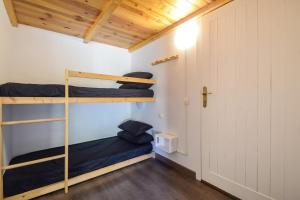 Pokój z 2 łóżkami piętrowymi i drzwiami w obiekcie Encantador ático estudio delante GrandValira HUT 5163 w mieście El Tarter