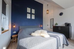 a blue bedroom with a bed with a white blanket at DOCK10TEXEL in De Cocksdorp