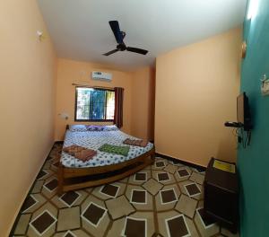 a bedroom with a bed and a ceiling fan at Kshanbhar Vishranti Home Stay in Malvan