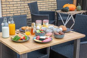 ein Holztisch mit Tellern voller Speisen und Getränke in der Unterkunft DOCK10TEXEL in De Cocksdorp