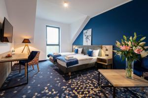 Ilkus Hotel & Restaurant في Krze: غرفة نوم بسرير كنج وجدار ازرق