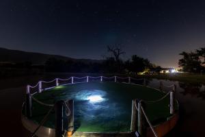a small pool in the middle of a lake at night at Klipfontein Rustic Farm & Camping in Tulbagh