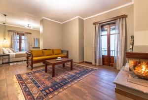uma sala de estar com um sofá e uma lareira em Ef Zin Hotel Arachova em Arachova
