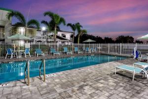 uma piscina com cadeiras e guarda-sóis à noite em Quality Inn Bradenton - Sarasota North em Bradenton