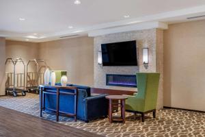a hotel room with a lobby with a tv and chairs at Comfort Inn & Suites in Clarkston