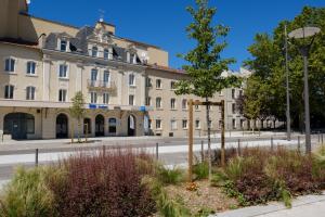 un grand bâtiment sur le côté d'une rue dans l'établissement ibis budget Le Puy En Velay, au Puy-en-Velay