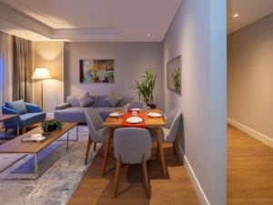 Movenpick Living Istanbul West في إسطنبول: غرفة معيشة مع طاولة طعام وأريكة