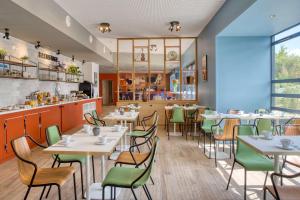 un restaurant avec des tables, des chaises et un comptoir dans l'établissement Best Western Hotel Atlantys Zenith Nantes, à Saint-Herblain