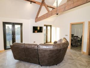 a brown leather couch sitting in a living room at Bear Cottage in Belper