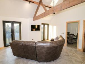 Bear Cottage في بيلبير: أريكة جلدية بنية الجلوس في غرفة المعيشة
