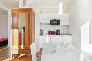 a white kitchen with a white table and chairs at Cadenabbia Lake side Apartments in Griante Cadenabbia