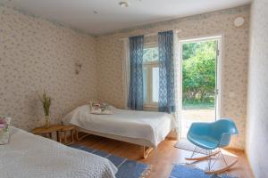 um quarto com uma cama, uma janela e uma cadeira em Saaristohotelli Vaihela em Velkua