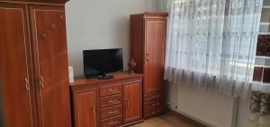 Habitación con TV en un tocador de madera con tocador en Apartament Kaduk, en Nowy Sącz