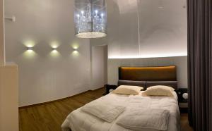 una camera con un grande letto e un lampadario a braccio di Tropicana Room a Caserta