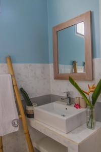 a bathroom with a white sink and a mirror at Divine Divers Gili Meno in Gili Meno