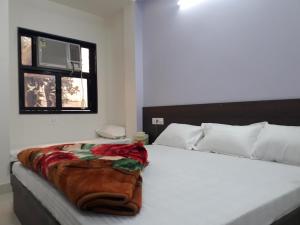 a bedroom with a bed with a blanket on it at Hotel Chouhan Paradise in Ajmer