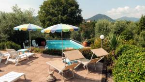 a patio with chairs and umbrellas next to a pool at B&B Renzano bedrooms in Salò