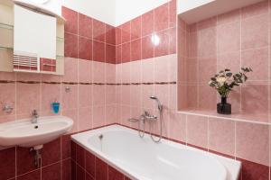 a bathroom with a sink and a tub and a sink at Penzion Tašner in Litomyšl