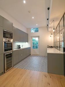 une cuisine avec des placards gris et un comptoir dans l'établissement FLH Seaside Luxury House in Porto, à Porto