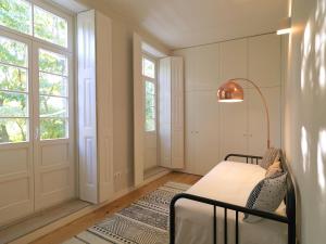 una camera con letto, lampada e finestre di FLH Seaside Luxury House in Porto a Porto
