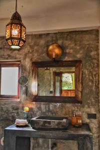 a bathroom with a sink and a mirror at Jardin d'Ulysse & Hard Rock in Morjim