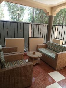 een afgeschermde veranda met stoelen en een tafel bij Palm Airport Suites in Nairobi
