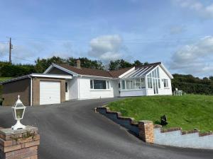a large white house with a driveway at 4 bedroom bungalow in peaceful countryside with log burner - Talar Deg, Capel Madog in Capel Madog