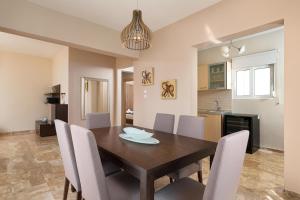 a dining room and kitchen with a wooden table and chairs at IL PARADISO DI MICHAIL in Phanaes