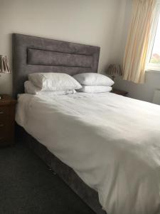 ein Bett mit weißer Bettwäsche und Kissen in einem Schlafzimmer in der Unterkunft Tivoli Place in Marske-by-the-Sea