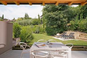 a white table and chairs on a patio at Lamasu RioVerde - Lago di Garda in San Felice del Benaco