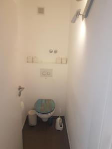 een badkamer met een toilet en een blauwe stoel bij Zimmer 1 nahe Thoraxklinik - Bad und Küche geteilt in Heidelberg