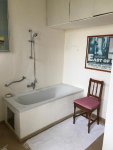 a bath tub in a room with a chair at Sattelzimmer und Studio in Pischeldorf