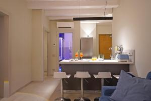 a kitchen and living room with a counter and chairs at Lamasu RioVerde - Lago di Garda in San Felice del Benaco