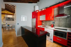 cocina con armarios rojos y lavadora en Top2Stay Málaga, en Málaga