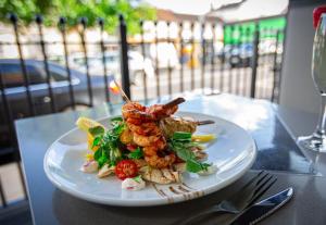 a plate of food with shrimp and vegetables on a table at The Crown Hotel Bawtry-Doncaster in Bawtry