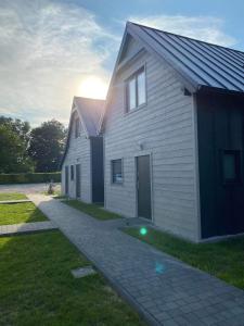 una casa blanca con entrada junto a un edificio en Gościnny Zakątek en Chłopy