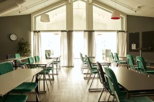 una classe con tavoli, sedie verdi e finestre di Hasse på Sjökanten Hotell & Restaurang a Jönköping