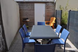 una mesa negra y sillas azules en un patio en L Etoile De La Mer, en Berck-sur-Mer