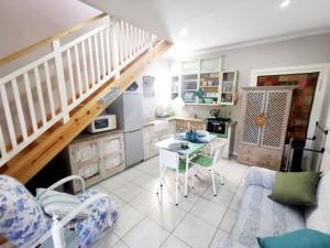 a kitchen with a staircase and a table in a room at The Coelacanth Guest House And Beach Thyme Self Catering in Kiddʼs Beach
